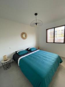 ein großes Bett in einem Schlafzimmer mit einer blauen Decke in der Unterkunft Loc a Machja Fiurita 1 ET 2 in Pietrosella