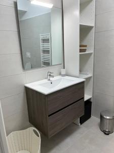 un bagno con lavandino e specchio di Loc a Machja Fiurita 1 ET 2 a Pietrosella Altre 29 foto