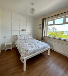 a bedroom with a bed and a large window at Breenville Farm House in Tralee