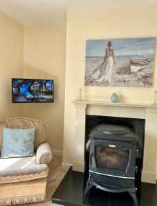 a living room with a fireplace with a picture on the wall at Breenville Farm House in Tralee
