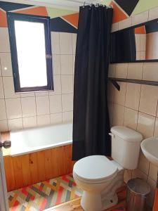 a bathroom with a toilet and a sink and a window at Cabaña Totoralillo in Coquimbo