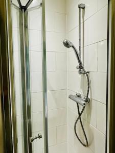 a shower with a shower head in a bathroom at George Hotel & Granary in Frome