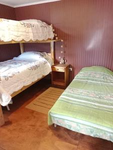 a bedroom with two beds and a night stand with a bedskirts at Cabaña Totoralillo in Coquimbo