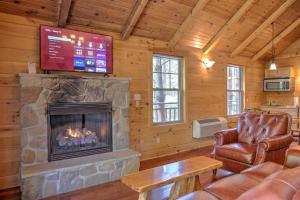 uma sala de estar com lareira e televisão em Whispering Pines Treehouse by Amish Country Lodging em Millersburg
