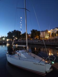 a man sitting on a sailboat in the water at night at Botnia Mini Racer in Rīga