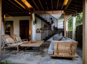a living room with a couch and a table and stairs at De Ubud Villas & Spa in Ubud
