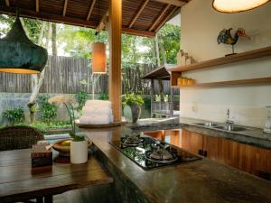a kitchen with a counter with a stove top oven at De Ubud Villas & Spa in Ubud