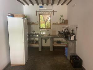 a kitchen with a table and a refrigerator in a room at Diana Place in Paje