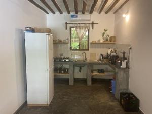 Diana Place في باجي: مطبخ مع ثلاجة بيضاء ومغسلة