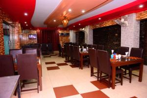 een restaurant met houten tafels en stoelen en een rood plafond bij Mir Continental Hotel & Restaurant in Muzaffarabad