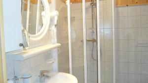 Un baño con ducha con lavabo y espejo. en Residenza Grazia, en Madonna di Campiglio 11 fotos más