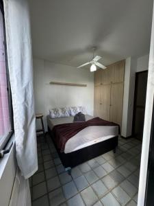 een slaapkamer met een bed en een plafondventilator bij Apartamento Beira Mar - Maceió in Maceió