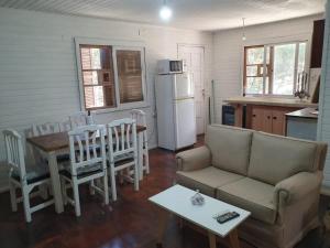 a living room with a couch and a table and a kitchen at Doha, paraíso mar y bosque in Rincón de los Oliveras