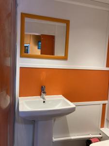 a bathroom with a white sink and a mirror at Acapulco Rooms in Portsmouth