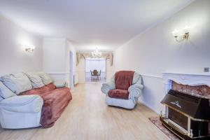 a living room with a couch and chairs and a piano at Pass the Keys Spacious 4-Bedroom Home in Benfleet in Battlesbridge