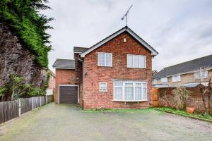 a brick house with a driveway in front of it at Pass the Keys Spacious 4-Bedroom Home in Benfleet in Battlesbridge