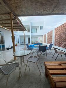 a patio with tables and chairs in a building at Hostel Killamoon Centro in Paracas