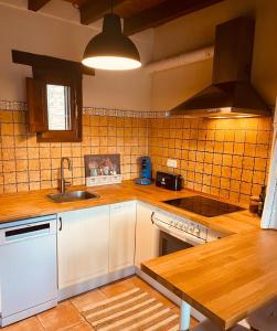 a kitchen with a sink and a stove top oven at La Casita de Chocolate - Encanto Rural en Espinoso de Compludo - El Bierzo in Ponferrada