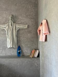 a towel hanging on a wall next to a shelf with books at Dar Maha - Amazing villa - pool 15x5M can be heated in Essaouira