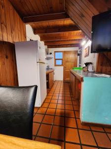 Il comprend une cuisine équipée d'un réfrigérateur blanc. dans l'établissement Quiñehuen, à San Martín de los Andes