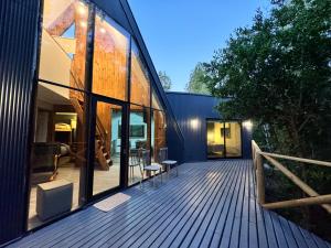 a house with a wooden deck with glass doors at Inspiramide Pucon in Pucón