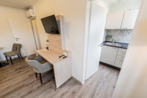 a small apartment with a desk and a kitchen at Hökis-Zimmervermietung 11 mit Küche in Brande-Hörnerkirchen +1 photo