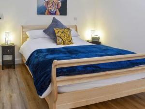 a bedroom with a large bed with a blue blanket at Blundens Holiday Lets - Ffos Las in Chichester