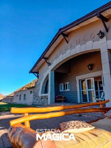 a building with a bunch of logs in front of it at Hotel Termas Lahuen-Có in Los Molles