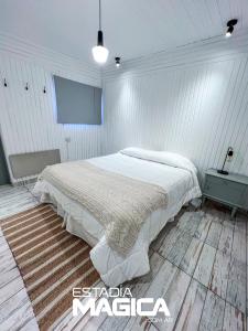 ロス・モレスにあるHotel Termas Lahuen-Cóの白いベッドルーム(ベッド1台、テーブル付)