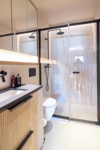 a bathroom with a toilet and a glass shower at La Ruinette- Stylish 4-bed, Centre Of Verbier in Verbier