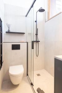 a bathroom with a toilet and a glass shower stall at La Ruinette- Stylish 4-bed, Centre Of Verbier in Verbier