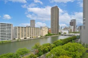 a view of a river in a city with buildings at Hotel NCB in Osaka