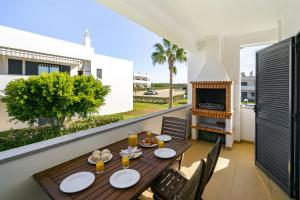 un tavolo e sedie su un balcone con camino di Vilita Oasis Family Apartment a Pêra