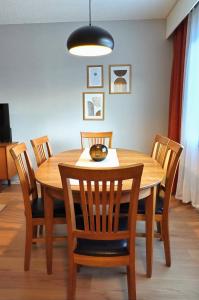 uma mesa de jantar em madeira com cadeiras e um candeeiro em Tilava kt Kaksio em Jalasjärvi