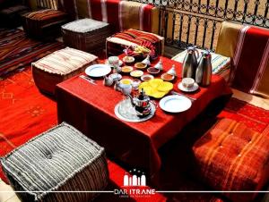 uma mesa vermelha com pratos e pratos em Panorama ait Hani Tinghir em Tinghir