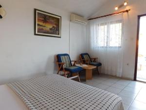 a bedroom with a bed and two chairs and a table at Holiday House Rivi in Milna