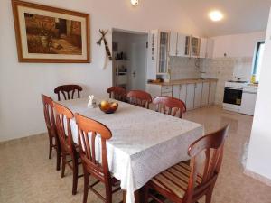 a dining room with a table and chairs and a kitchen at Holiday House Rivi in Milna