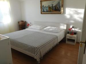 a bedroom with a bed and a picture on the wall at Holiday House Rivi in Milna
