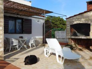 a black dog laying on the ground next to a chair at Holiday House Rivi in Milna