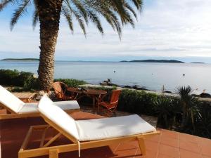 a patio with chairs and a view of the ocean at Holiday House Rivi in Milna