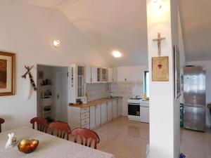 a kitchen with a table with apples on it at Holiday House Rivi in Milna