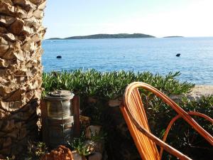 a bench and a thermos sitting next to the water at Holiday House Rivi in Milna