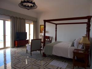 a bedroom with a large bed and a television at Jasmine Bay Hotel & Spa 