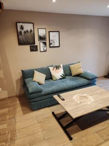 Sala de estar con sofá azul y mesa de centro en LaMaisonnette_au_36, en Angulema