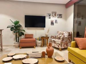 uma sala de estar com mobiliário e uma televisão de ecrã plano em Glamorous 2BR/ Free Beach & Pool Access @ Mangroovy, El Gouna em Hurghada
