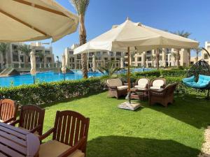 un patio con sedie e ombrelloni di fronte al resort di Glamorous 2BR/ Free Beach & Pool Access @ Mangroovy, El Gouna a Hurghada