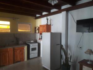 a kitchen with a white refrigerator and a stove at Ratto 463 in Concepción del Uruguay