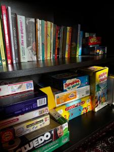 a shelf filled with lots of books at E L chalet. A cosy mountain retreat. in Palaios Agios Athanasios