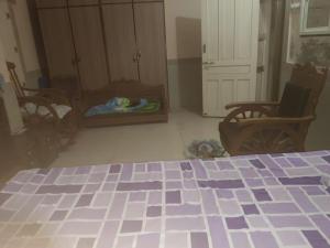 a bedroom with a bed and chairs and a dog bed at Ram Nivas Home Stay Dwarka in Dwarka