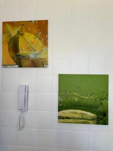 - une salle de bains avec deux peintures et un téléphone sur un mur dans l'établissement Amplio Departamento en Zona Gastronómica a una cuadra de la Playa, à Mar del Plata
